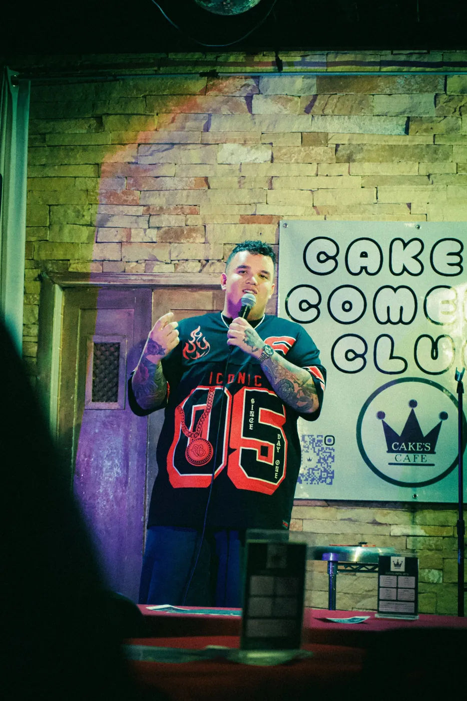 AJ Deleon on stage at Cake's Comedy Club
